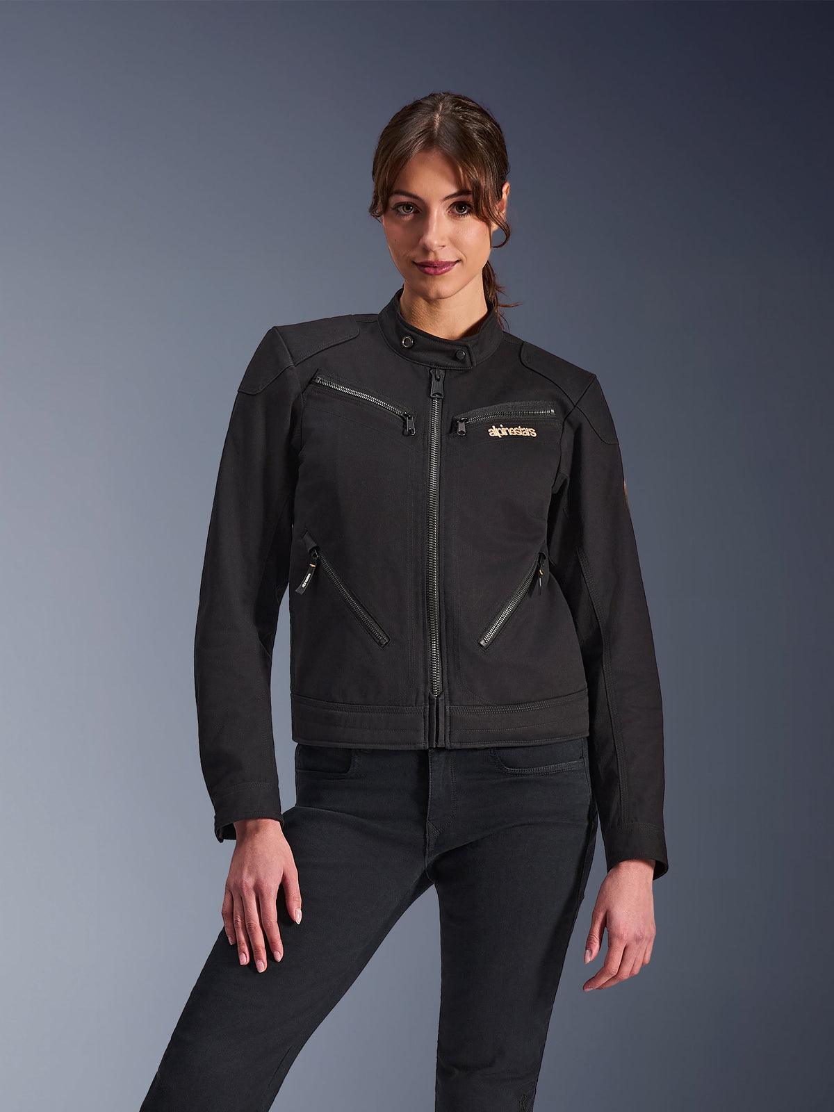 Alpinestars Woman Stella Grace Jacket, Urban Motorcycle Jacket, Black, front view, featuring multiple zippered pockets and a snap collar, worn with black jeans, modern lifestyle-inspired protective gear for women