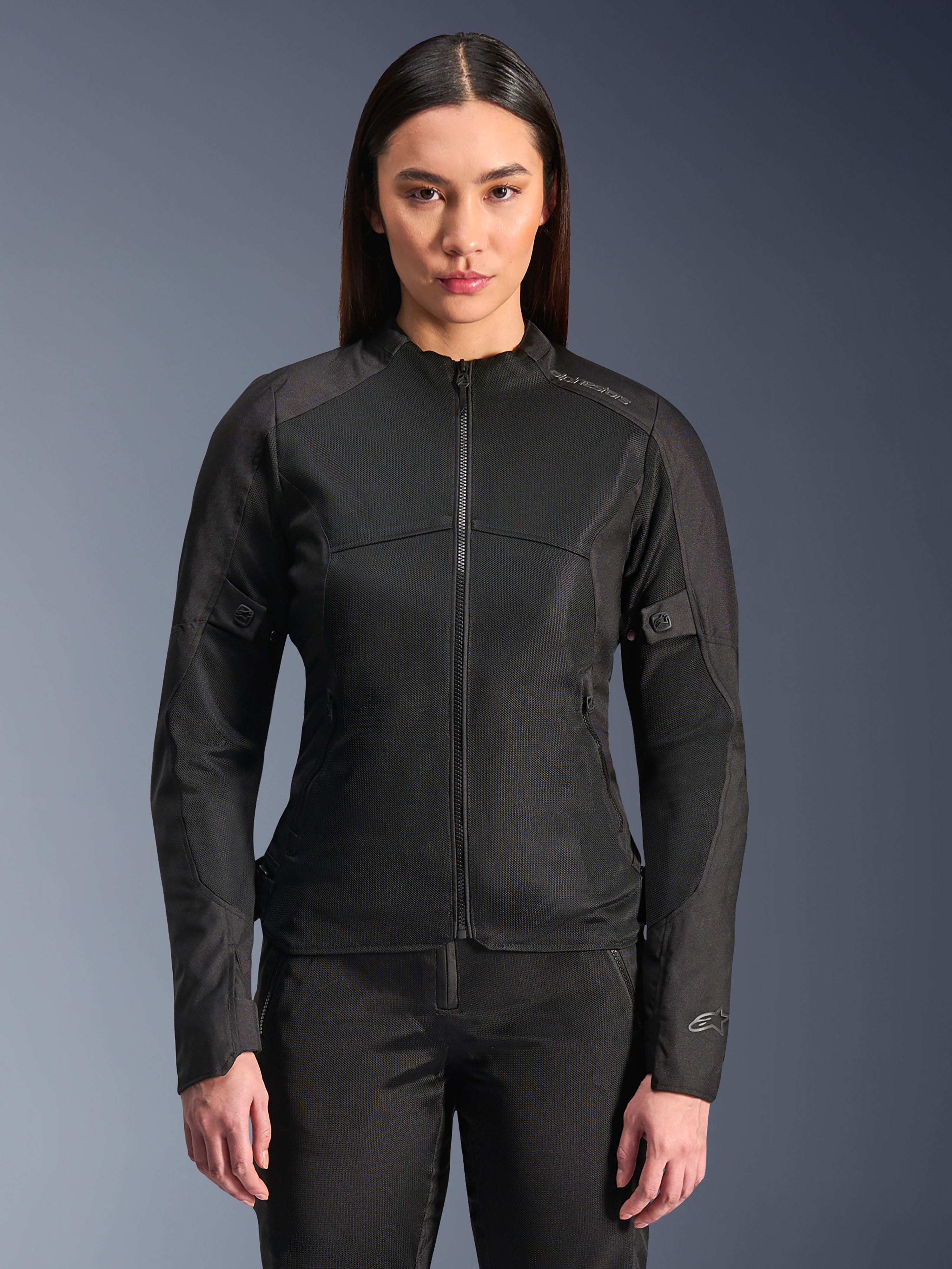 Kurtka Alpinestars Stella C-1 Air, damska kurtka motocyklowa, czarna, modelka w dopasowanej kurtce zapinanej na zamek z panelami z siatki technicznej, krój slim fit z subtelnymi odblaskowymi logotypami na ramieniu i mankiecie rękawa