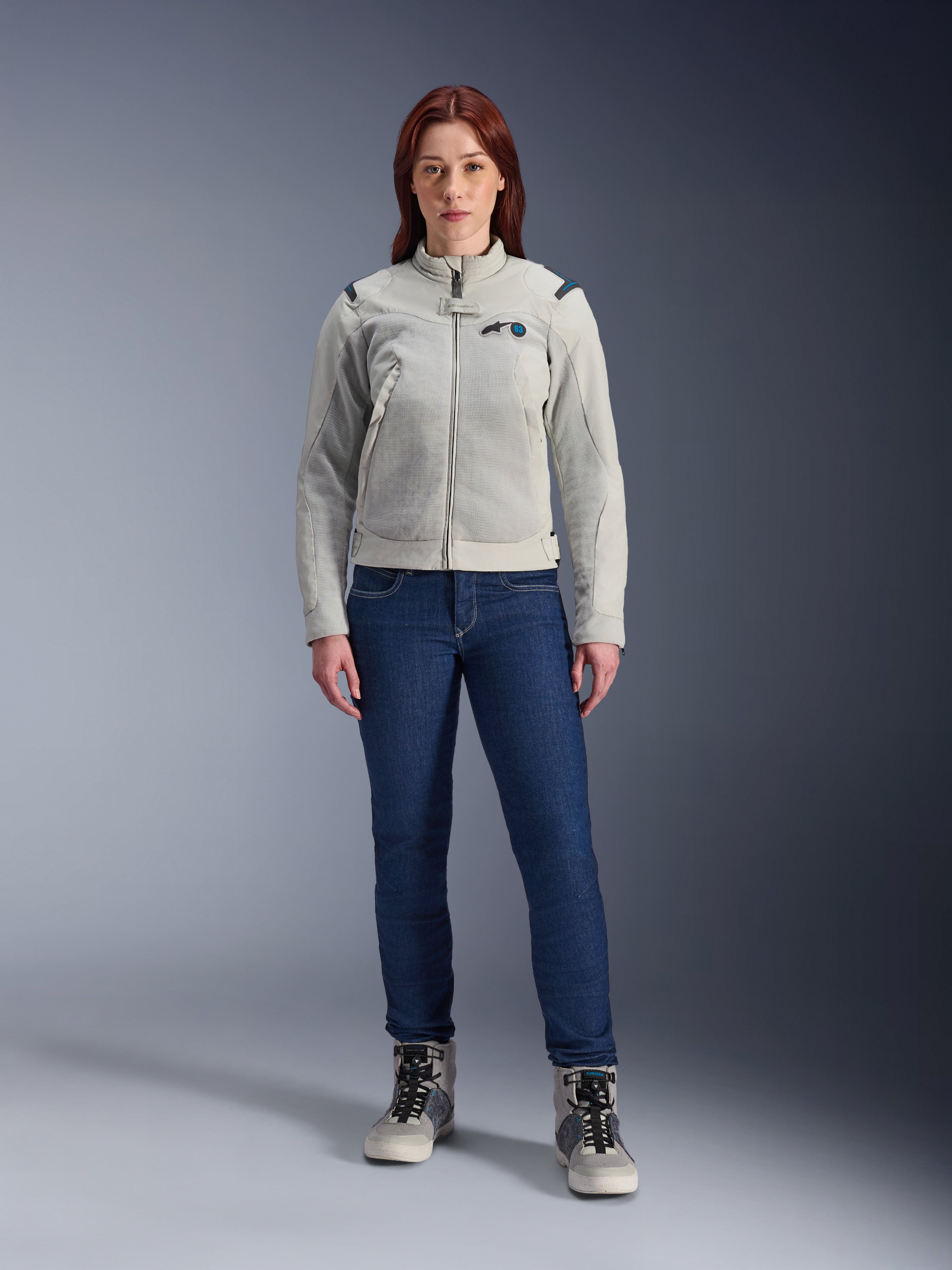 Alpinestars Stella CIRCAL-1 Air Jacket, damska kurtka motocyklowa, kolor Metal Gray i Methyl Blue, noszona z ciemnoniebieskimi dżinsami i szarymi butami motocyklowymi, wyposażona w panele z siatki zapewniające wentylację i nowoczesny miejski design