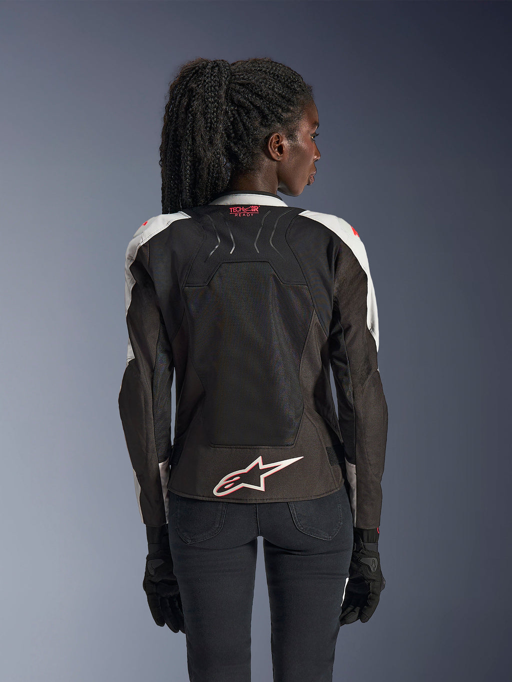 Kurtka Alpinestars Stella SMX Air, damska kurtka motocyklowa, kolor lodowoszary i czarny z akcentami Coral Fluo, widok z tyłu prezentujący branding Tech-Air Ready i białe logo Astar, siatkowa konstrukcja zapewniająca wysoką wentylację, sportowy krój