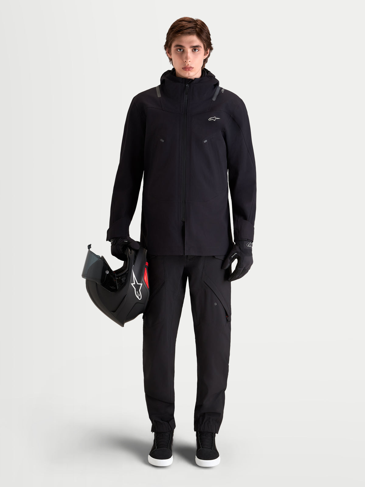 Alpinestars Juggernaut V 2 Drystar spodnie motocyklowe męskie urban contemporary, czarne, pełny widok z przodu na model w pasującej kurtce i z kaskiem, wodoodporna konstrukcja tekstylna