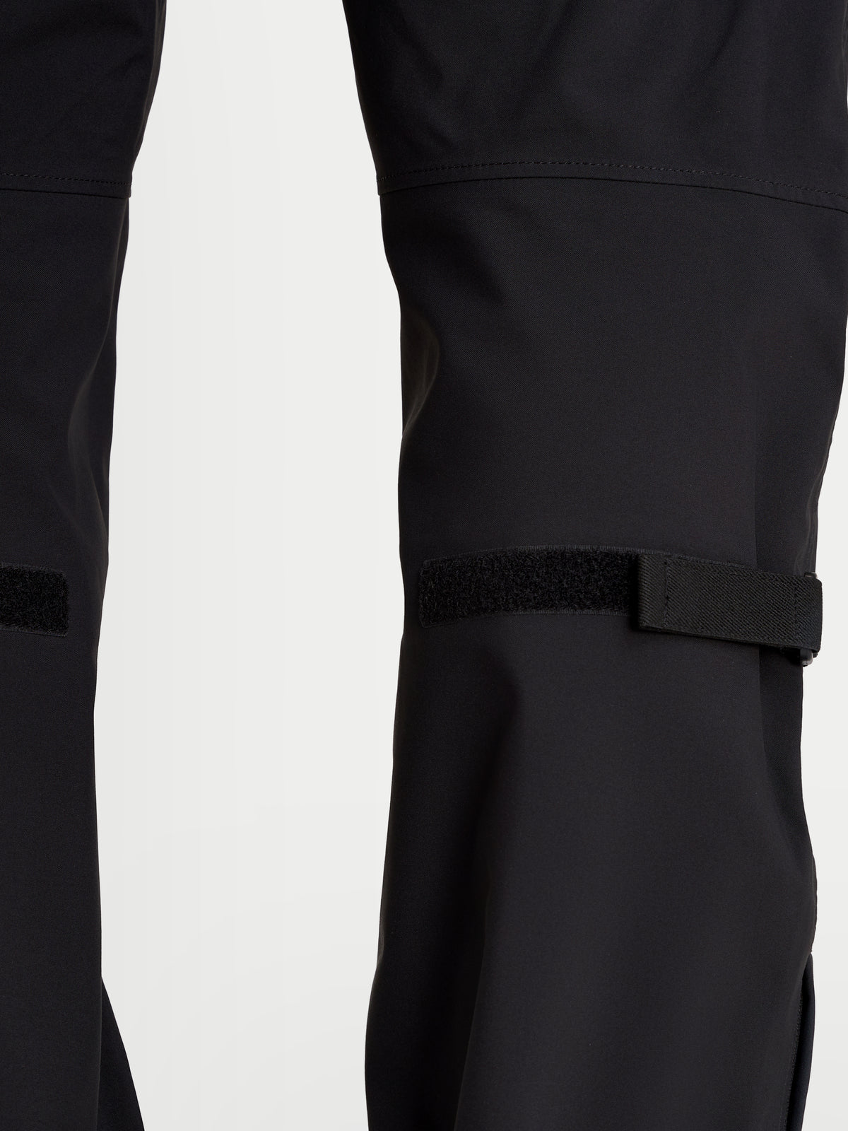 Alpinestars Juggernaut V2 Drystar spodnie motocyklowe męskie urban, czarne, zbliżenie pokazujące regulatory nogawek i tekstylną konstrukcję techniczną