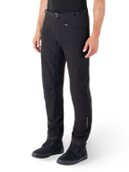 Alpinestars Alden Pants, miejskie spodnie motocyklowe, czarne, techniczna tkanina softshell o regularnym kroju, magnetyczna klamra w pasie, pikowane panele boczne, kieszenie na zamek i subtelne logo na dolnej części nogawki, noszone z czarnymi butami motocyklowymi