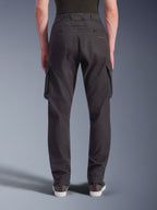 Alpinestars Flex-AST Cargo Pants - Short, miejskie spodnie motocyklowe, czarne, widok z tyłu prezentujący regularny, zwężany krój, elastyczne mankiety, duże boczne kieszenie cargo i subtelne logo na tylnej kieszeni, noszone z codziennymi sneakersami