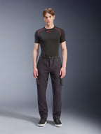 Alpinestars Flex-AST Cargo Pants - Short, czarne, prezentowane przez męskiego modela w czarnej koszulce technicznej i czarnych sneakersach, miejskie spodnie motocyklowe z licznymi kieszeniami cargo, zwężany krój, wbudowany pasek z klamrą i pierścieniem D-ring