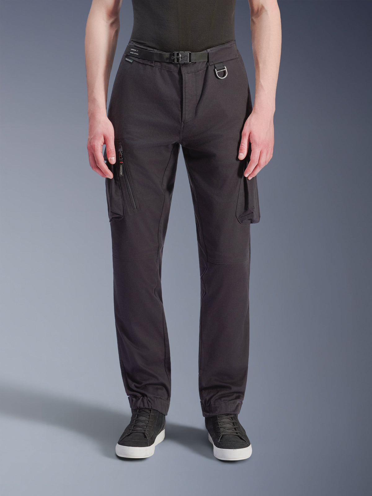 Alpinestars Flex-AST Cargo Pants - Short, czarne miejskie spodnie motocyklowe, widok z przodu, techniczna elastyczna tkanina, liczne kieszenie cargo z zamkiem błyskawicznym z boku, szlufka z metalowym pierścieniem D, regularny zwężany krój z elastycznymi mankietami, noszone z czarnymi sneakersami
