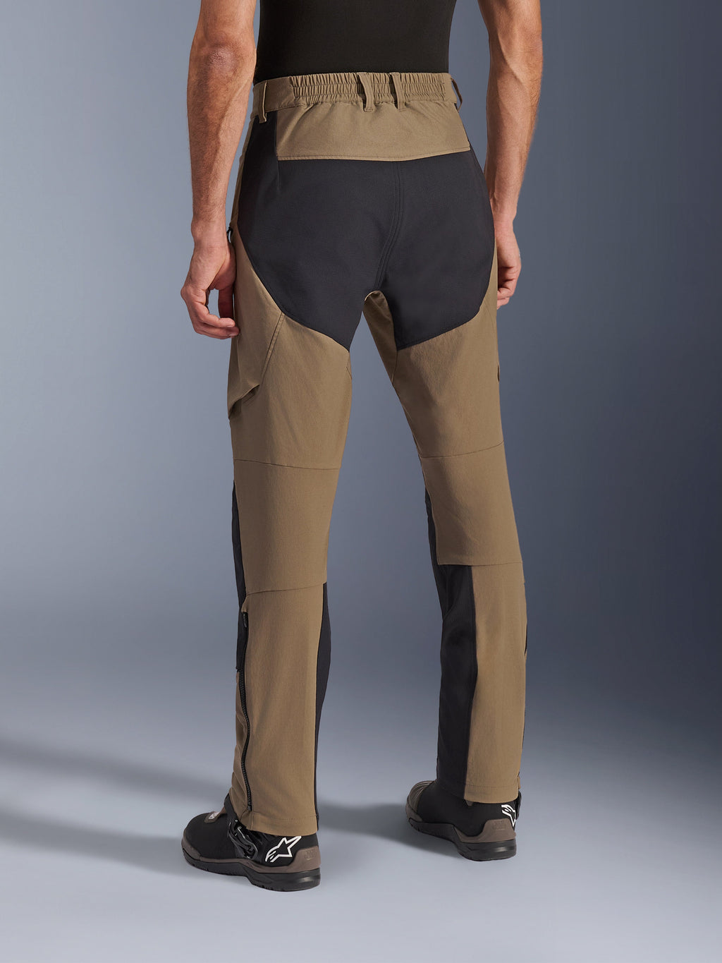 Alpinestars Flex-AST Explorer Pants, spodnie motocyklowe adventure Walnut Black, widok z tyłu ukazujący czarne panele ripstop na siedzeniu i nogawkach, elastyczny pas i wytrzymała konstrukcja z elastycznego materiału tekstylnego.