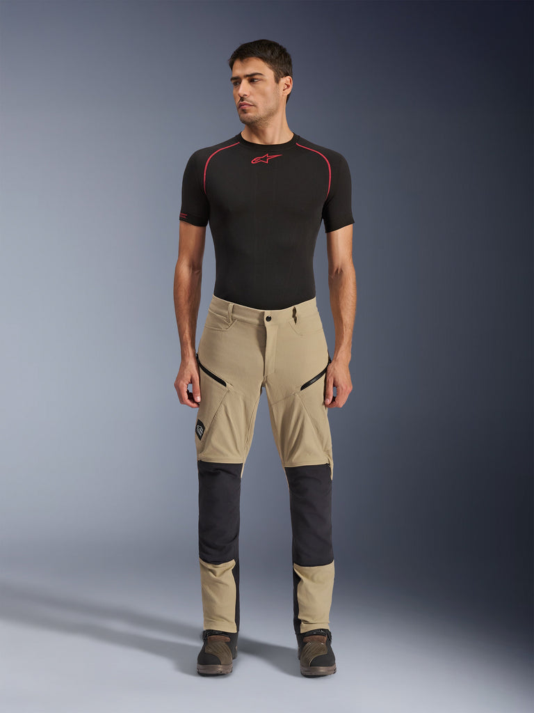 Alpinestars Flex-AST Explorer Pants, Motorcycle Adventure Pants, Beige and Black, featuring reinforced knee panels, zippered cargo pockets, and ripstop construction, worn by a model in a front-facing studio shot.