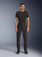 Spodnie Alpinestars Flex-AST Canvas, miejskie spodnie motocyklowe, czarne, prezentowane przez modela w czarnej warstwie bazowej z krótkim rękawem i czerwonymi przeszyciami oraz czarnych codziennych sneakersach, podkreślone przednie kieszenie na zamek i ergonomiczny design z materiału canvas.
