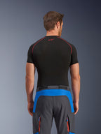 Alpinestars Maxdura Dual Pants, spodnie motocyklowe adventure, kolor królewski niebieski i ciemnoszary, widok z tyłu, noszone z czarną warstwą bazową z krótkim rękawem, niebieskie panele akcentujące w górnej części tyłu, pomarańczowe kieszenie cargo na zamek, techniczna odzież do jazdy dual-sport