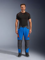Spodnie Alpinestars Maxdura Dual, motocyklowe spodnie adventure, niebieskie i ciemnoszare z pomarańczowymi akcentami przy zamkach, zestawione z czarną warstwą bazową Alpinestars i czarnymi butami, wzmocnione panele na kolanach i techniczny design off-road