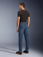 Alpinestars Flex-AST 5 Denim Pants, Indigo Washed, widok z tyłu modelu w spodniach, miejskie jeansy motocyklowe, zwężany krój z jednowarstwowego elastycznego denimu, zestawione z czarnym t-shirtem i czarnymi sneakersami