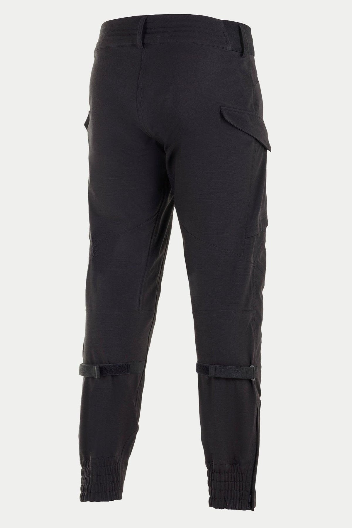 Alpinestars Juggernaut Waterproof Pants, czarne spodnie motocyklowe, widok z tyłu z elastycznymi mankietami przy kostkach, regulacją objętości łydek i kieszeniami cargo, 3-warstwowa konstrukcja softshell do jazdy miejskiej i szosowej