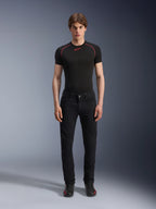 Spodnie Alpinestars Copper V3 Denim w kolorze Black Rinse, wygodny krój regularny z prostymi nogawkami, prezentowane przez modela w czarnej koszulce termoaktywnej z czerwonymi kontrastowymi szwami i czarnych butach motocyklowych, miejski zestaw odzieży motocyklowej