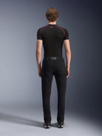 Spodnie Alpinestars Copper V3 Denim w kolorze Black Rinse, widok z tyłu na modelu, motocyklowe dżinsy o prostym kroju wykonane z elastycznego denimu, zestawione z czarną koszulką kompresyjną z krótkim rękawem i butami do jazdy, miejska odzież motocyklowa