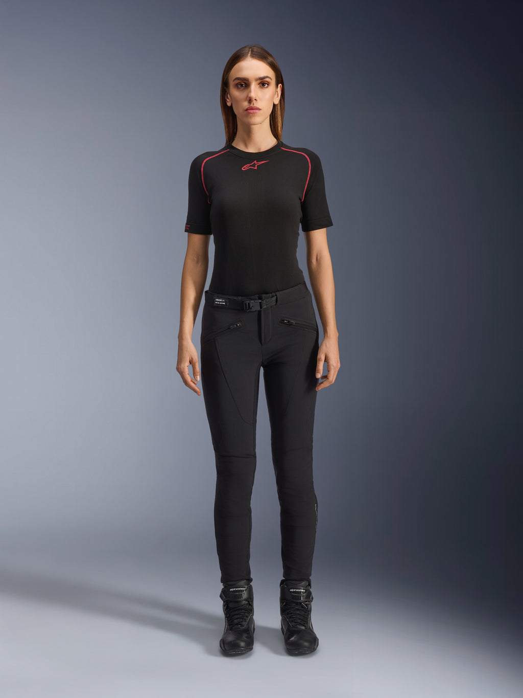 Alpinestars Alamosa Women Pants, czarne dopasowane spodnie motocyklowe, zaprezentowane na modelce przodem, z przednimi kieszeniami na zamek i zintegrowanym paskiem w talii, minimalistyczny styl inspirowany streetwearem do jazdy miejskiej