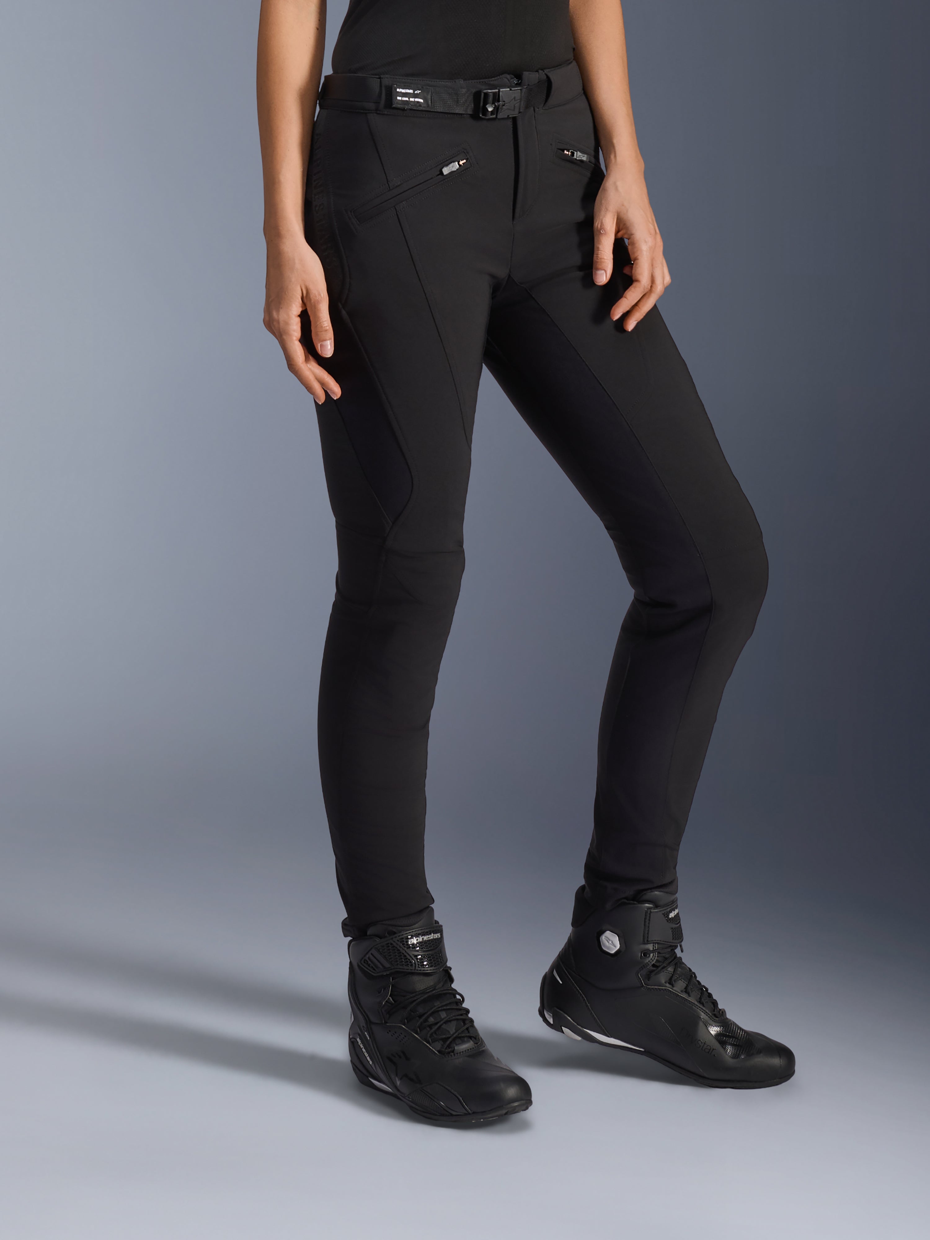 Alpinestars Alamosa Women Pants, czarne miejskie spodnie motocyklowe, dopasowany krój z kieszeniami na zamek i zintegrowanym paskiem w talii, zestawione z czarnymi wysokimi butami motocyklowymi