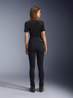 Legginsy Alpinestars Stella Flex-Ast, damskie legginsy motocyklowe, czarne, widok z tyłu prezentujący dopasowany krój z wysokim stanem, zestawione z czarną koszulką z krótkim rękawem i czarnymi butami motocyklowymi, miejska odzież motocyklowa