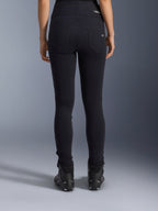 Legginsy Alpinestars Stella Flex-Ast, damskie legginsy motocyklowe, czarne, widok z tyłu ukazujący tylne kieszenie i dopasowany krój, noszone z czarnymi butami motocyklowymi, miejski styl jazdy