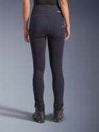 Legginsy Alpinestars Stella Flex-AST, miejskie spodnie motocyklowe, czarne, widok z tyłu prezentujący wysoki stan i dopasowany krój skinny, dwie funkcjonalne kieszenie tylne z subtelnym brandingiem, elastyczny materiał tekstylny, zestawione z czarnymi butami motocyklowymi