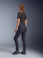 Alpinestars Stella Flex-Ast Leggings, damskie legginsy motocyklowe, czarne, widok z tyłu prezentujący wysoki stan i tylne kieszenie, zestawione z czarną warstwą bazową z krótkim rękawem i czerwonymi akcentami oraz czarnymi butami motocyklowymi, współczesna miejska odzież motocyklowa
