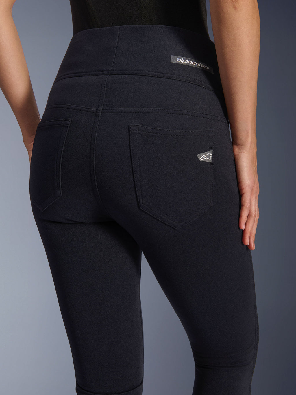 Alpinestars Stella Flex-Ast Leggings, damskie legginsy motocyklowe, czarne, widok z tyłu prezentujący wysoki stan, dwie tylne kieszenie, logo Alpinestars na pasie i prawej kieszeni, dopasowany materiał do jazdy miejskiej
