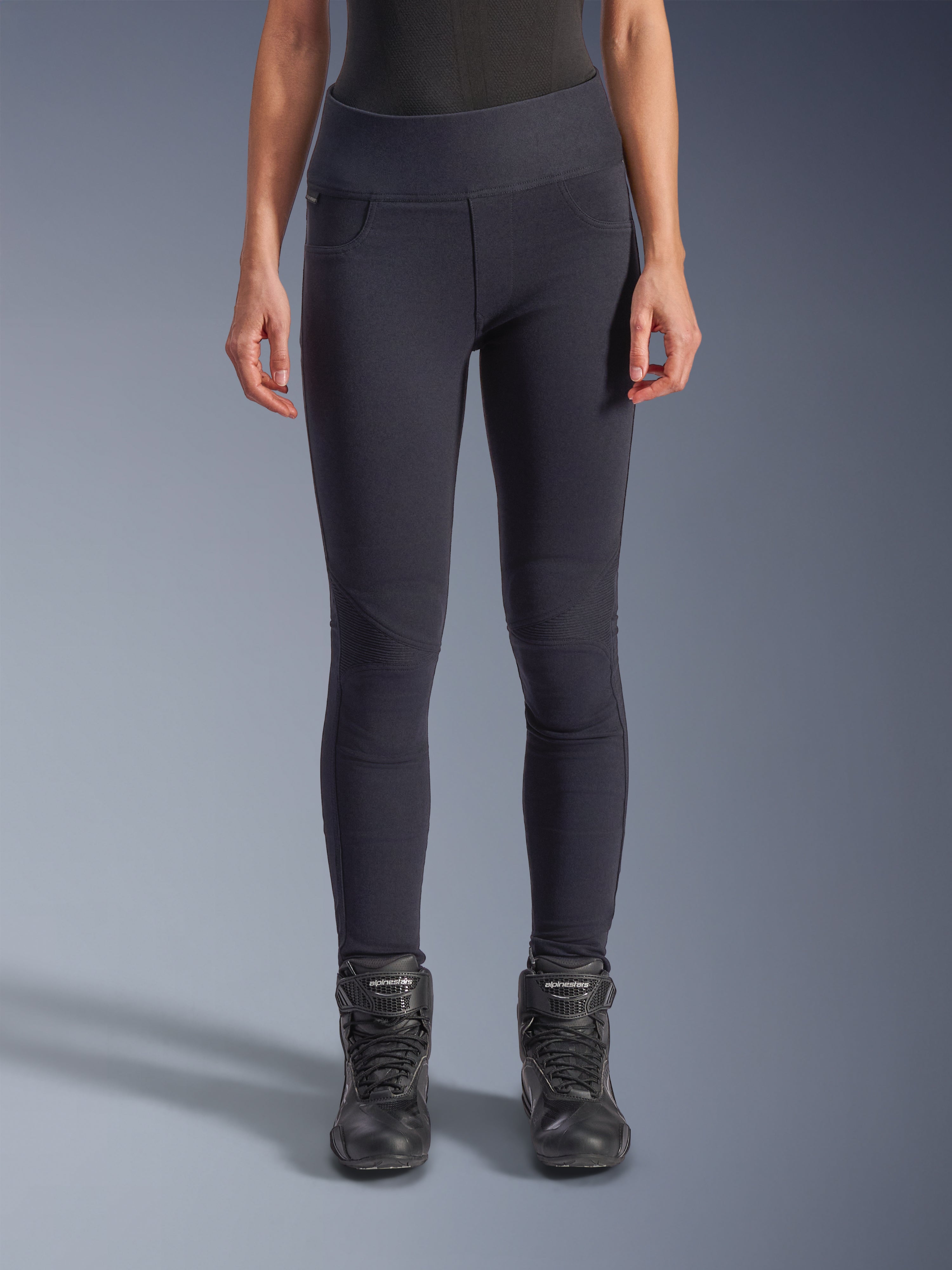 Alpinestars Stella Flex-Ast Leggings, damskie legginsy motocyklowe, czarne, wysoki stan, profilowane panele na kolanach i wyprofilowane szwy, prezentowane przez modelkę w czarnych butach motocyklowych, miejska odzież motocyklowa