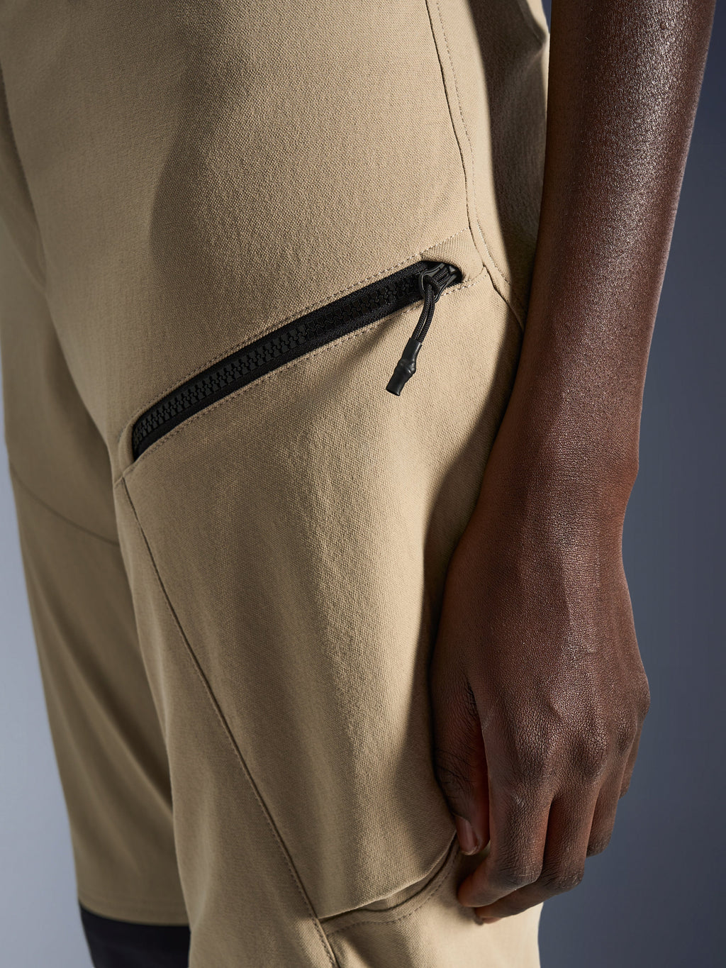 Alpinestars Woman Stella Flex-AST Explorer Pants in Sand, close-up of the hip and thigh area featuring a black diagonal zippered cargo pocket and durable ripstop textile fabric