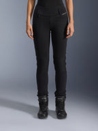 Alpinestars Womens Banshee Leggings, czarne spodnie motocyklowe, krój slim-fit z harmonijkowymi panelami na kolanach, noszone z czarnymi wysokimi butami motocyklowymi, miejska odzież motocyklowa w casualowym stylu