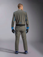 Alpinestars GP Race V3 Suit FIA, widok z tyłu, antracytowy błękit z wyrazistymi niebieskimi detalami na rękawach i ramionach, niebieskie logo gwiazdy na dole pleców, noszony z pasującymi rękawicami wyścigowymi i niebieskimi butami, profesjonalny kombinezon do wyścigów samochodowych