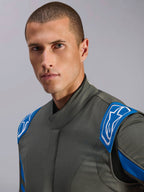 Alpinestars GP Race V3 Suit FIA, samochodowy kombinezon wyścigowy w kolorze Anthracite Blue, zbliżenie na górną część kombinezonu z niebieskimi epoletami na ramionach i białym logo Alpinestars, profesjonalny sprzęt motorsportowy