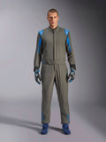 Alpinestars GP Race V3 Suit FIA, samochodowy kombinezon wyścigowy w kolorze Anthracite Blue, noszony z pasującymi rękawicami i butami wyścigowymi, jasnoniebieskie epolety na ramionach i paski na rękawach, detale z logo Alpinestars, profesjonalna ochrona do wyścigów torowych