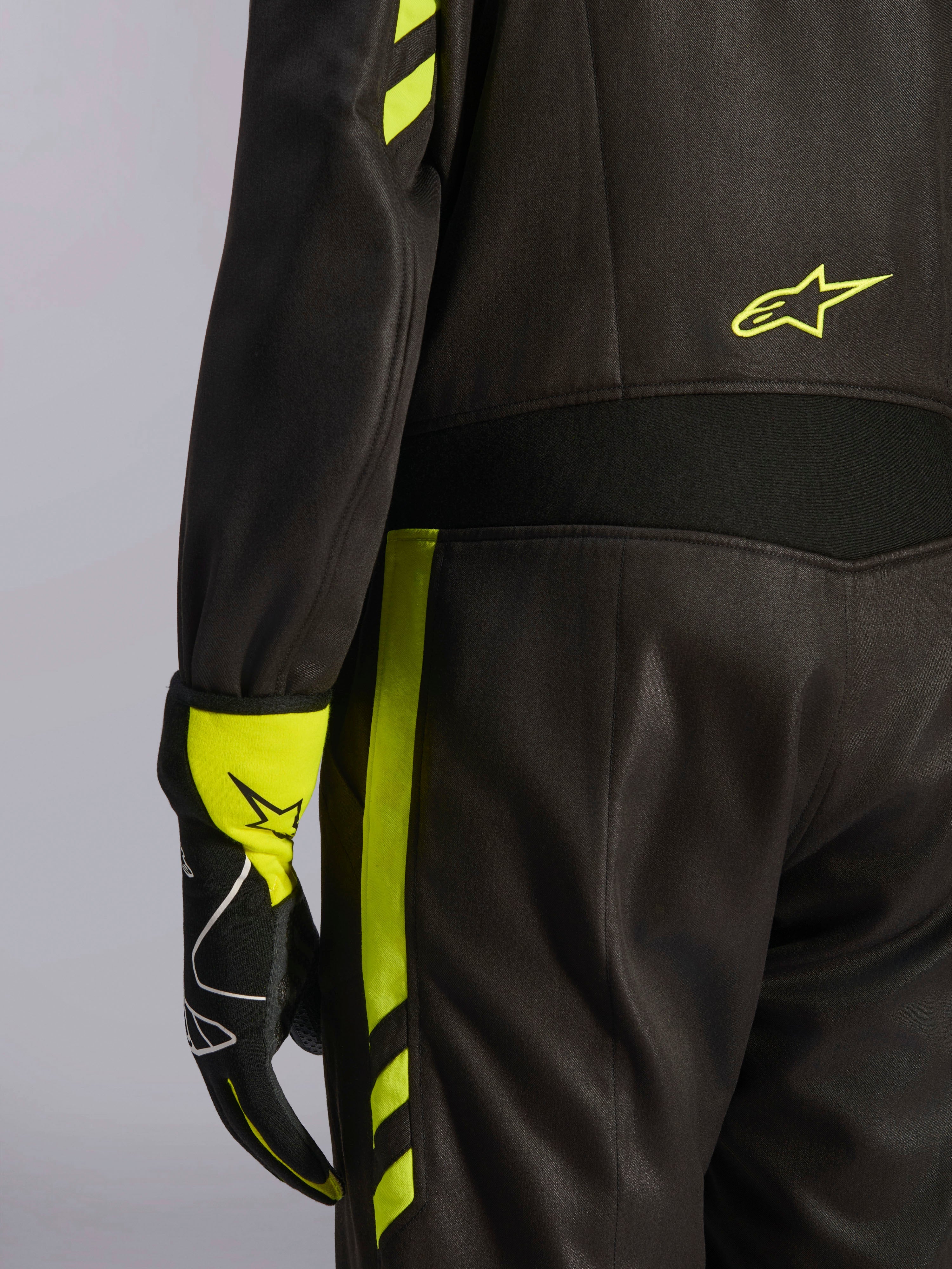 Alpinestars GP Race V3 Suit FIA, czarny i żółty fluorescencyjny, zbliżenie na talię i bok nogawki, aramidowe panele elastyczne i dopasowana rękawica wyścigowa, profesjonalna odzież do wyścigów samochodowych