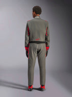 Widok z tyłu modelu ubranego w kombinezon Alpinestars GP Race V3 w kolorze Anthracite Red, profesjonalny kombinezon wyścigowy z czerwonymi akcentami na rękawach i nogawkach, w połączeniu z czerwonymi butami wyścigowymi i czarnymi rękawicami, techniczna odzież motorsportowa pokazana w studio.