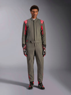 Alpinestars GP Race V3 Suit FIA, kombinezon samochodowy, antracytowo-czerwony, prezentowany przez modela z dopasowanymi rękawicami i butami, posiada czerwone epolety i logo marki, profesjonalna odzież do sportów motorowych.