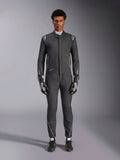 Alpinestars Hypertech V3 Suit, profesjonalny samochodowy kombinezon wyścigowy, czarny i Dark Shadow, prezentowany przez modela z dopasowanymi rękawicami i butami wyścigowymi, dopasowany sportowy krój ze srebrnymi akcentami i brandingiem, wyczynowa odzież motorsportowa