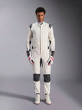 Kombinezon Alpinestars Hypertech V3, profesjonalny kombinezon samochodowy, biało-czarno-srebrny, prezentowany przez modela z czerwono-białymi rękawicami i pasującymi białymi butami wyścigowymi, z czarnymi kontrastowymi panelami i logo Alpinestars, sportowy, dopasowany krój