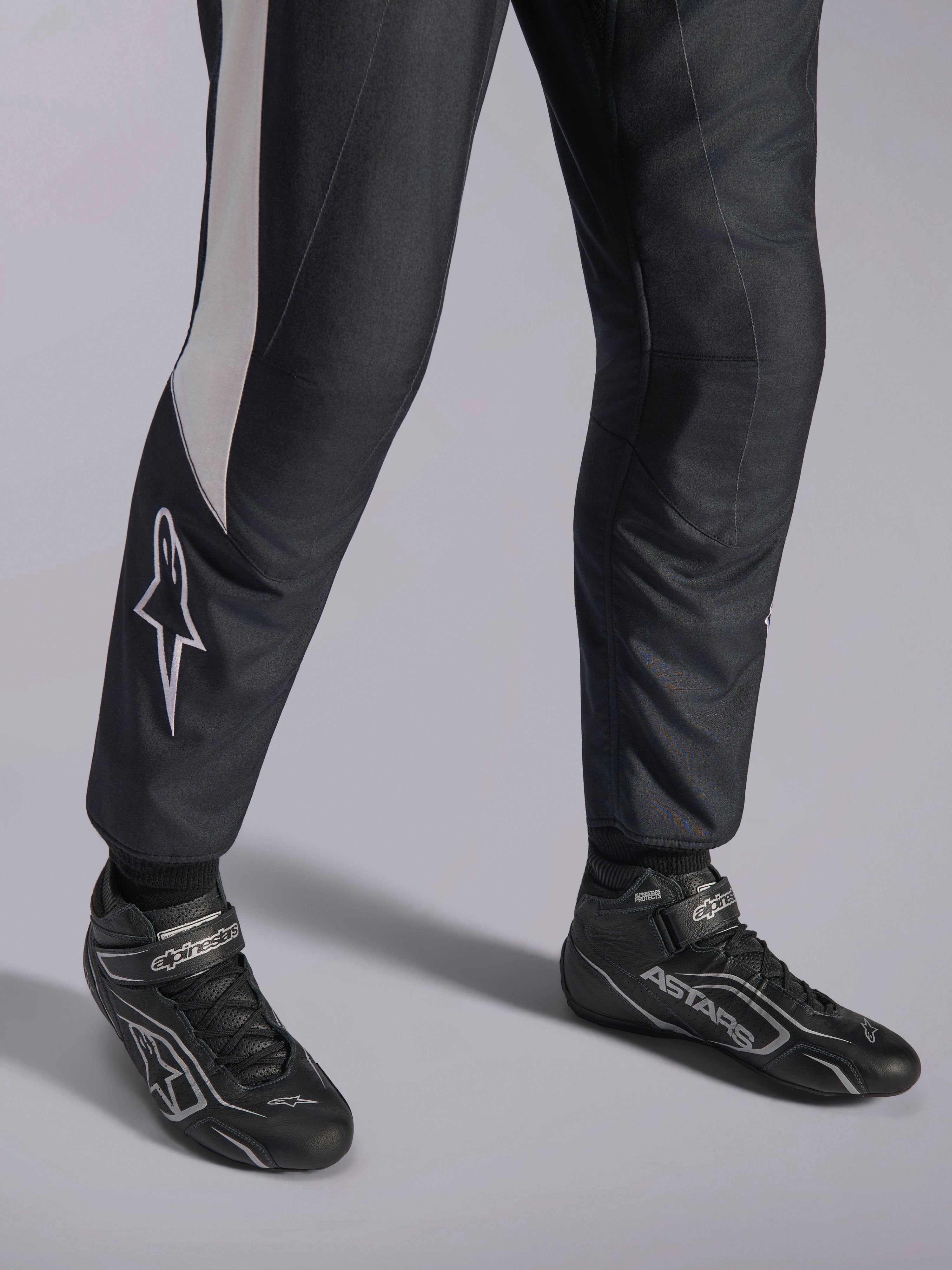 Kombinezon Alpinestars GP Pro Comp V2 FIA, czarny i biały strój wyścigowy, zbliżenie na buty ASTARS.