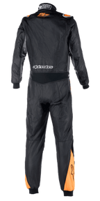 Alpinestars Atom FIA Graphic Suit, widok z tyłu jednoczęściowego kombinezonu wyścigowego, czarny i antracytowy z pomarańczowymi akcentami Fluo na barkach i łydkach, widoczna certyfikacja FIA na kołnierzu oraz branding Alpinestars w dolnej części pleców.