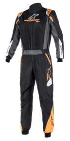 Alpinestars Atom FIA Graphic Suit, czarno-antracytowy z jaskrawopomarańczowymi akcentami fluo, jednoczęściowy kombinezon wyścigowy z certyfikatem FIA, wysoki kołnierz, logo ASTARS na rękawach, profesjonalna odzież do sportów motorowych i zawodów na torze