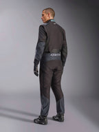 Kombinezon Alpinestars KMX-5 V3 w kolorze Black Dark Shadow, widok z tyłu na modela w pełnym stroju kartingowym z dopasowanymi rękawicami i butami wyścigowymi, logo Alpinestars na pasie, ciemnoszare akcenty, profesjonalny sprzęt kartingowy.