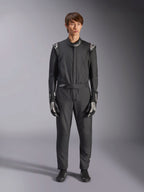 Kombinezon Alpinestars GP Tech V4, czarno-biały, profesjonalny jednoczęściowy kombinezon samochodowy, noszony z dopasowanymi czarno-białymi rękawicami i butami wyścigowymi, z białymi logo Alpinestars na ramionach i kołnierzu, dopasowany krój sportowy do sportów motorowych
