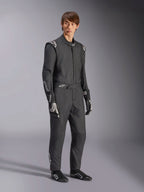Alpinestars GP Tech V4 Suit, jednoczęściowy samochodowy kombinezon wyścigowy, czarno-biały, noszony z dopasowanymi rękawicami i obuwiem wyścigowym, białe logo na ramionach i przedramionach, profesjonalny design do sportów motorowych