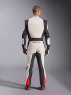 Alpinestars GP Tech V4 Suit, samochodowy kombinezon wyścigowy, biało-czarno-czerwony, widok od tyłu na kierowcę w jednoczęściowym kombinezonie, czarne elastyczne panele po bokach i na ramionach, czerwone akcenty na dolnej części nogawek, branding Alpinestars na dole pleców i kołnierzu, profesjonalny sprzęt wyścigowy z certyfikatem FIA