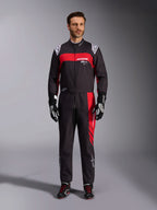Alpinestars KMX-9 V3 Graphic 3 Suit, kombinezon kartingowy, czarno-czerwony, widok od przodu na modelu, wyraziste czerwone panele graficzne i białe logo, czarne rękawice i buty wyścigowe, profesjonalna odzież do sportów motorowych