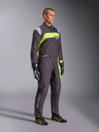 Męski model w kombinezonie Alpinestars KMX-9 V3 Graphic 3 w kolorze czarnym i żółtym fluorescencyjnym, profesjonalny strój kartingowy z jaskrawymi neonowymi żółtymi panelami i białymi akcentami logo, z dopasowanymi rękawicami i butami wyścigowymi, na tle studyjnym.