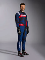 Model wearing the Alpinestars KMX-9 V3 Graphic 5 Suit in Navy Red, full-body shot including black karting gloves and black racing shoes, navy blue suit with dark camo-style graphics and a prominent red chest panel with white branding, professional karting protective gear