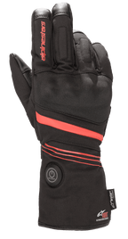 Alpinestars HT-5 Heat Tech Drystar® Gloves, podgrzewane rękawice motocyklowe, czarne z czerwonymi akcentami, okrągły przycisk zasilania na mankiecie, czerwone paski na dłoni i nadgarstku, logo Alpinestars na palcu, zapewniające wodoodporną ochronę w zimne dni