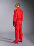 Alpinestars Kart Indoor V2 Suit, czerwony kombinezon kartingowy, widok z tyłu pod kątem trzech czwartych na modelu, zestawiony z pasującymi czerwonymi rękawicami i butami wyścigowymi, jednowarstwowa konstrukcja z kepru polibawełnianego, profesjonalny sprzęt motorsportowy do kartingu halowego.
