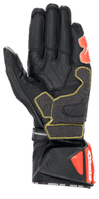Rękawice Alpinestars GP Tech V2, czarno-biało-czerwone fluo, widok od strony dłoni przedstawiający konstrukcję z czarnej skóry z żółtymi kontrastowymi szwami, ochronny mankiet DFS z czerwonymi akcentami, profesjonalny wyścigowy sprzęt motocyklowy